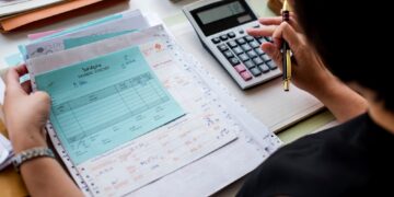 asian-woman-working-through-paperwork-min