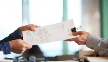 closeup-hands-passing-contract-unrecognizable-businessman-min