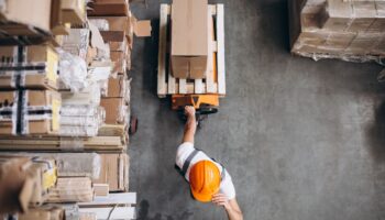 young-man-working-warehouse-with-boxes-min