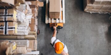 young-man-working-warehouse-with-boxes-min